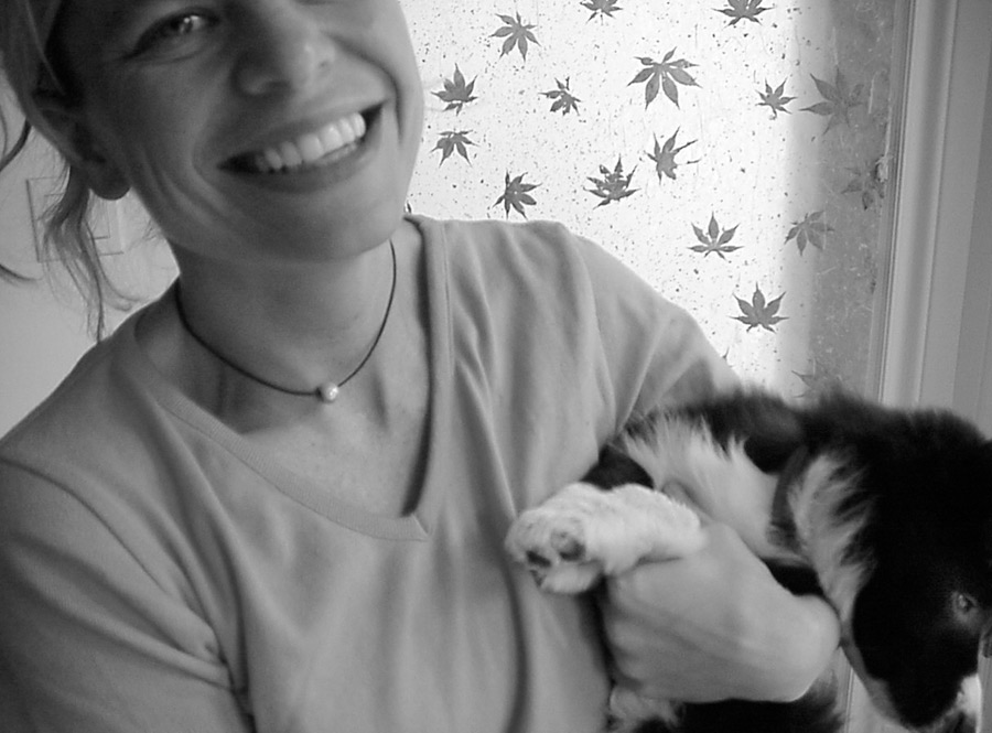Young woman smiling while holding her Border Collie puppy Young smiling woman holding puppy